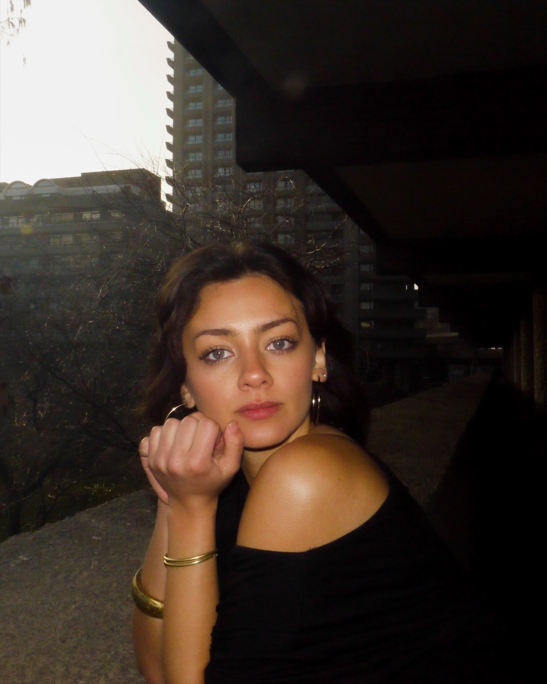 Portrait of Alexandra Isabel Diaz Winton, leaning on a concrete balustrade at dusk